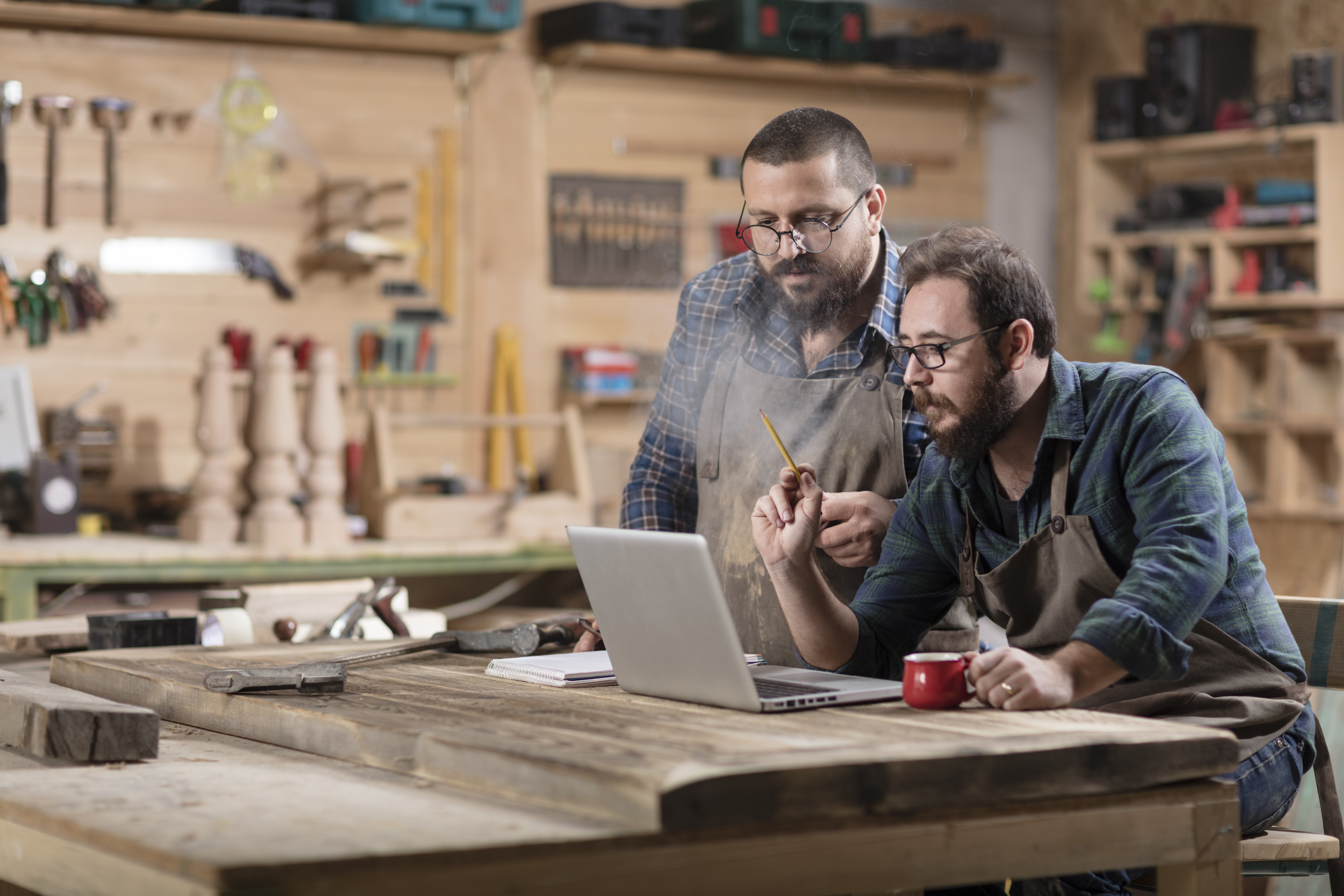 Add TDS Wi-Fi+ For Business Two white men sitting at a wood/tool workshop on a laptop