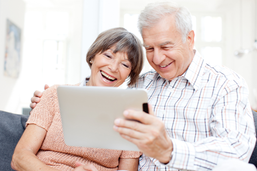 Family on couch looking at laptops and tablets High Speed Internet Service